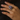 Close-up of a vintage black opal and diamond cocktail ring on a woman’s hand, showing the opal’s play-of-color with red, green, and blue flashes.